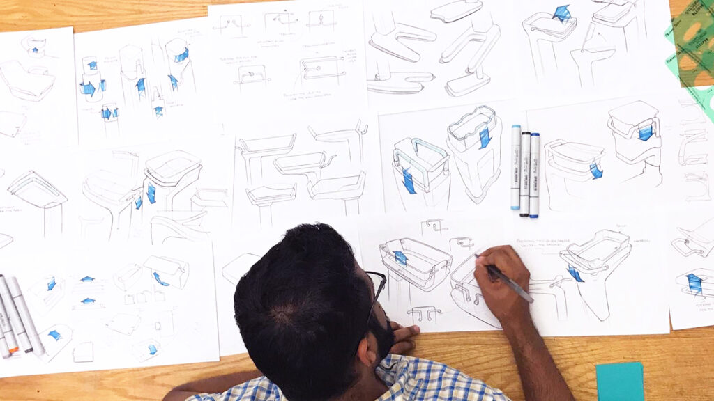 An overhead view of a designer working on sketches for a product design